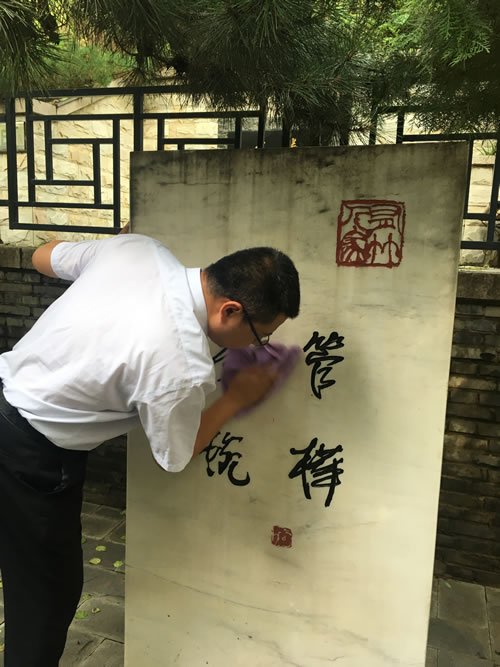 北京八达岭陵园员工为管桦先生墓碑擦拭灰尘