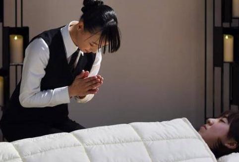 女入殓师双手合十，向“逝者”致意