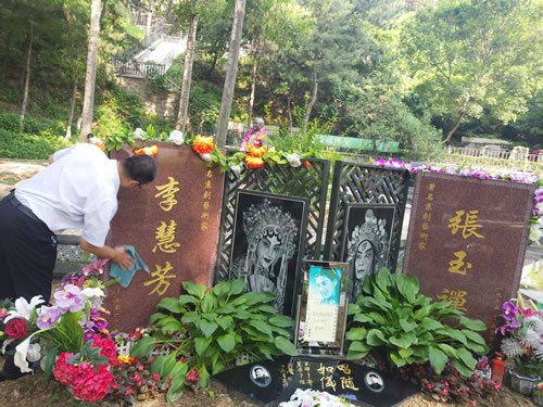 工作人员在擦拭李慧芳先生墓碑