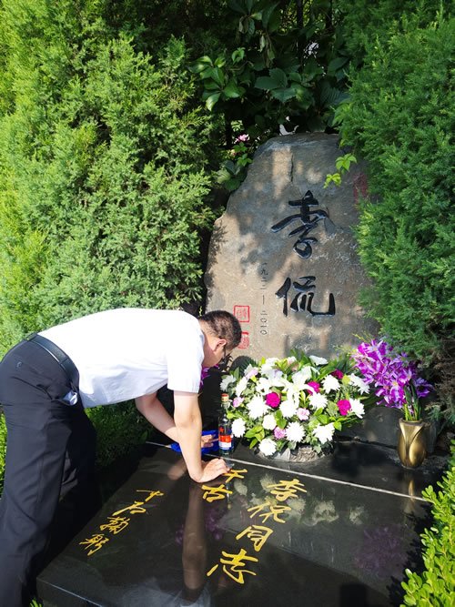 北京八达岭陵园工作人员为李侃先生墓碑擦拭灰尘
