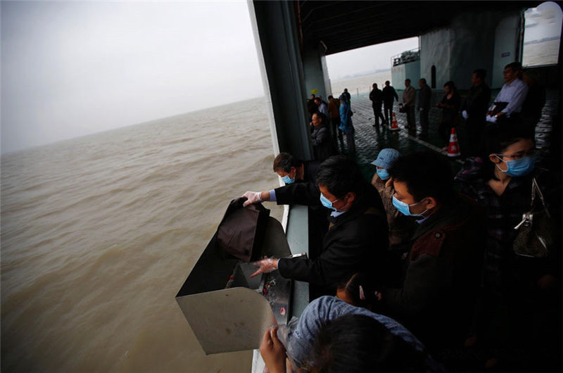 海葬渡轮上,人民将亲人的骨灰倒入大海之中