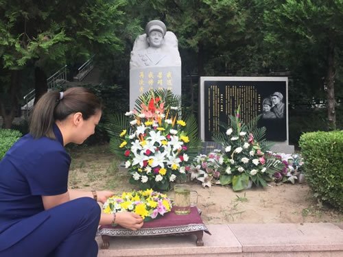 工作人员在李中权将军墓碑前排放花环