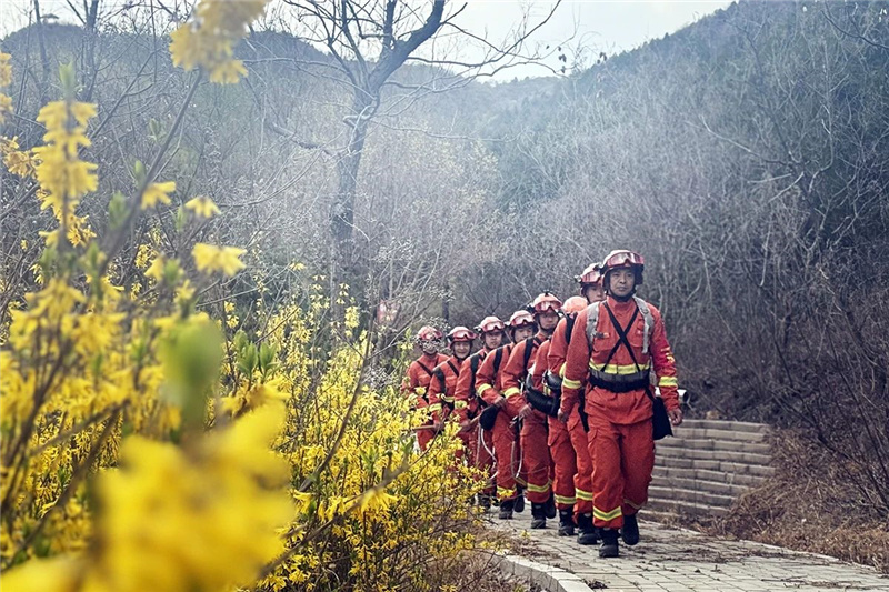 森林消防队员携带灭火设备在山林间巡逻