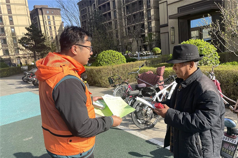 双丰街道“暖心橙”志愿者向居民发放文明祭扫倡议书