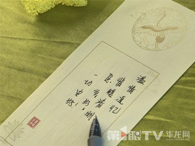 家属邓女士在水溶纸上写下对爷爷奶奶的思念。第1眼TV-华龙网 李舒 摄